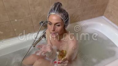 带<strong>香槟杯</strong>的浴缸里的女人